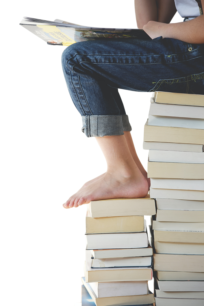 Person die beim lesen auf einem Buchstapel sitzt